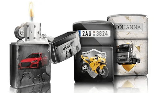 Drei metallische Feuerzeuge mit individuellen Designs: ein rotes Auto, ein gelbes Motorrad mit Kennzeichen und ein LKW mit der Aufschrift „JOHANNA“. Ein Feuerzeug ist geöffnet und die Flamme brennt.