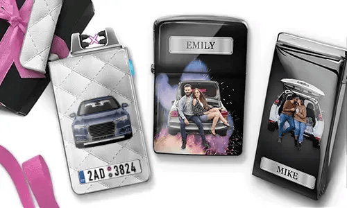 Drei personalisierte Zigarettenetuis sind zu sehen. Das erste zeigt ein Auto mit Kennzeichen. Das zweite zeigt ein Paar, das auf einem Auto sitzt, mit der Aufschrift „Emily“ vor farbenfrohem Hintergrund. Das dritte zeigt ein Paar im Kofferraum eines Autos, mit der Aufschrift „Mike“. Rosafarbene Schleifenakzente sind sichtbar.