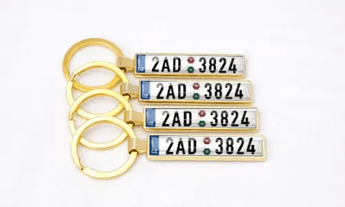 Gouden nummerplaat sleutelhangers tonen gepersonaliseerde nummers samen gerangschikt