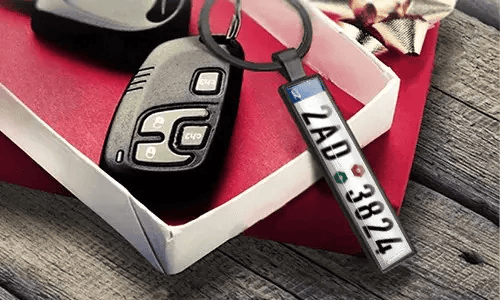 Metalnøglering med nummerplade viser graverede numre ved siden af bilnøglerne