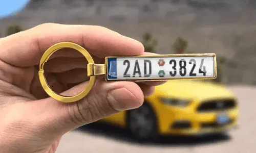 Il portachiavi dorato personalizzato mostra numeri di targa incisi