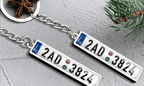 Metalowy brelok z tablicą rejestracyjną i detalem flagi