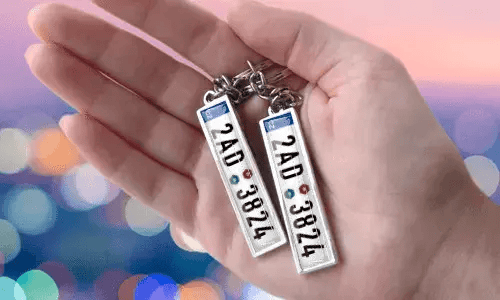 Portachiavi con targa personalizzata e numeri personalizzati, tenuto in mano