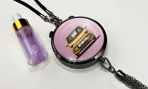Pendant with pink background and white sports car, next to purple dropper bottle with gold cap