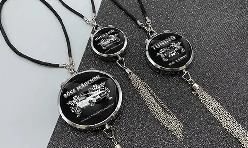 Three black pendants with chains: each with car graphic and German tuning slogan on glittery surface