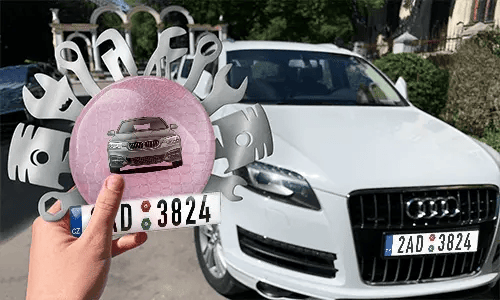 Autoschlüsselanhänger in der Hand mit dem Wagen auf dem Hintergrund individueller schlüsselanhänger